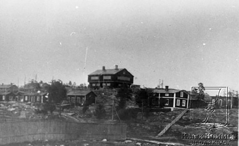 Höganloft var från början en samlingslokal. Utspridda runt berget är arbetarbostäderna, cirka 1900. Foto: Okänd – kalixbilder.se.