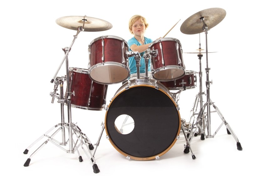Liten pojke spelar trummor.